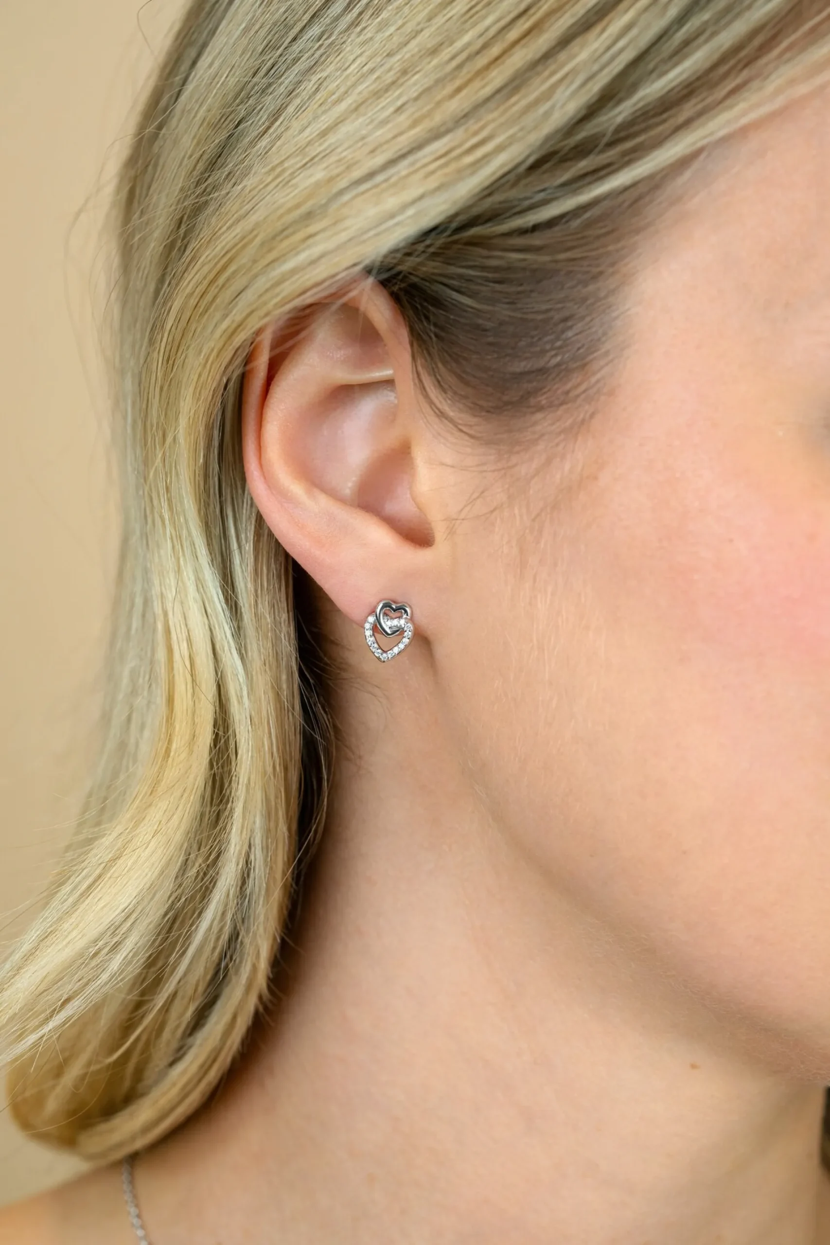 10mm ZINZI zilveren oorknoppen 2 open hartjes met elkaar verbonden, waarvan 1 hartje bezet met witte zirconia's ZIO2493