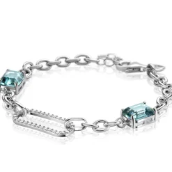 ZINZI zilveren fantasie schakel armband met ovale schakel, bezet met witte zirconia's en twee groenachtig blauwe (petrol) kleurstenen in vierpootszetting 18-21cm ZIA2487